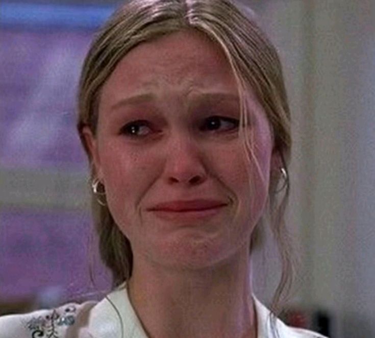 A close-up of a woman with tears in her eyes, showing a distressed expression.